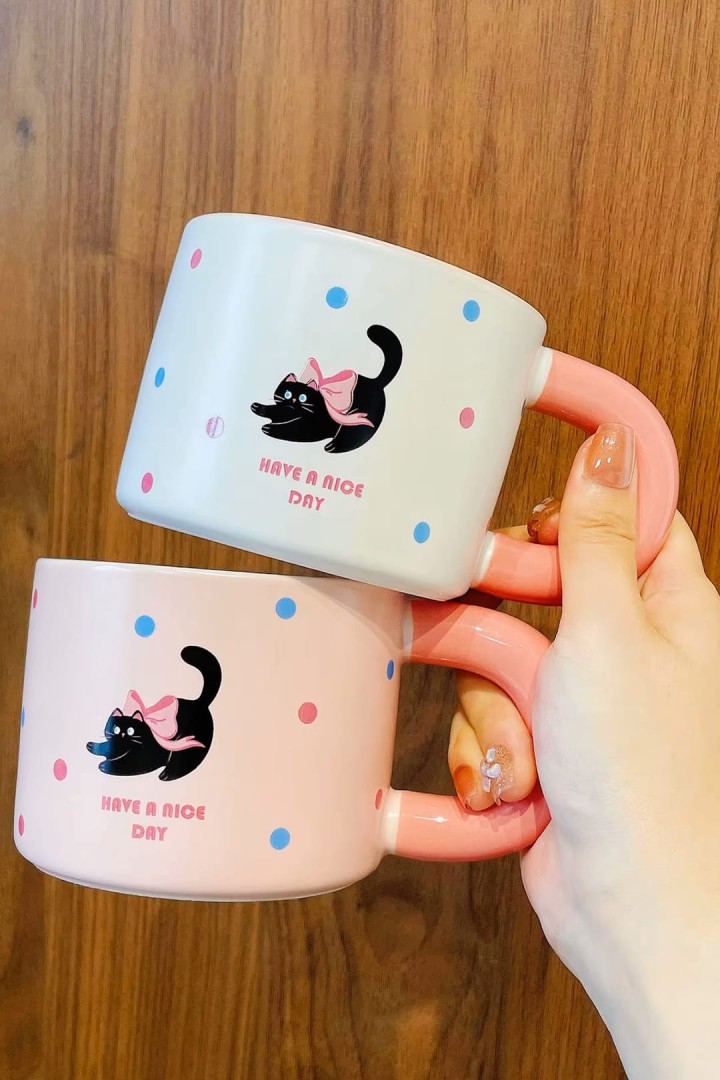 Tasse mit Tupfen und Katzen mit einem großen Ohr Schönen Tag noch